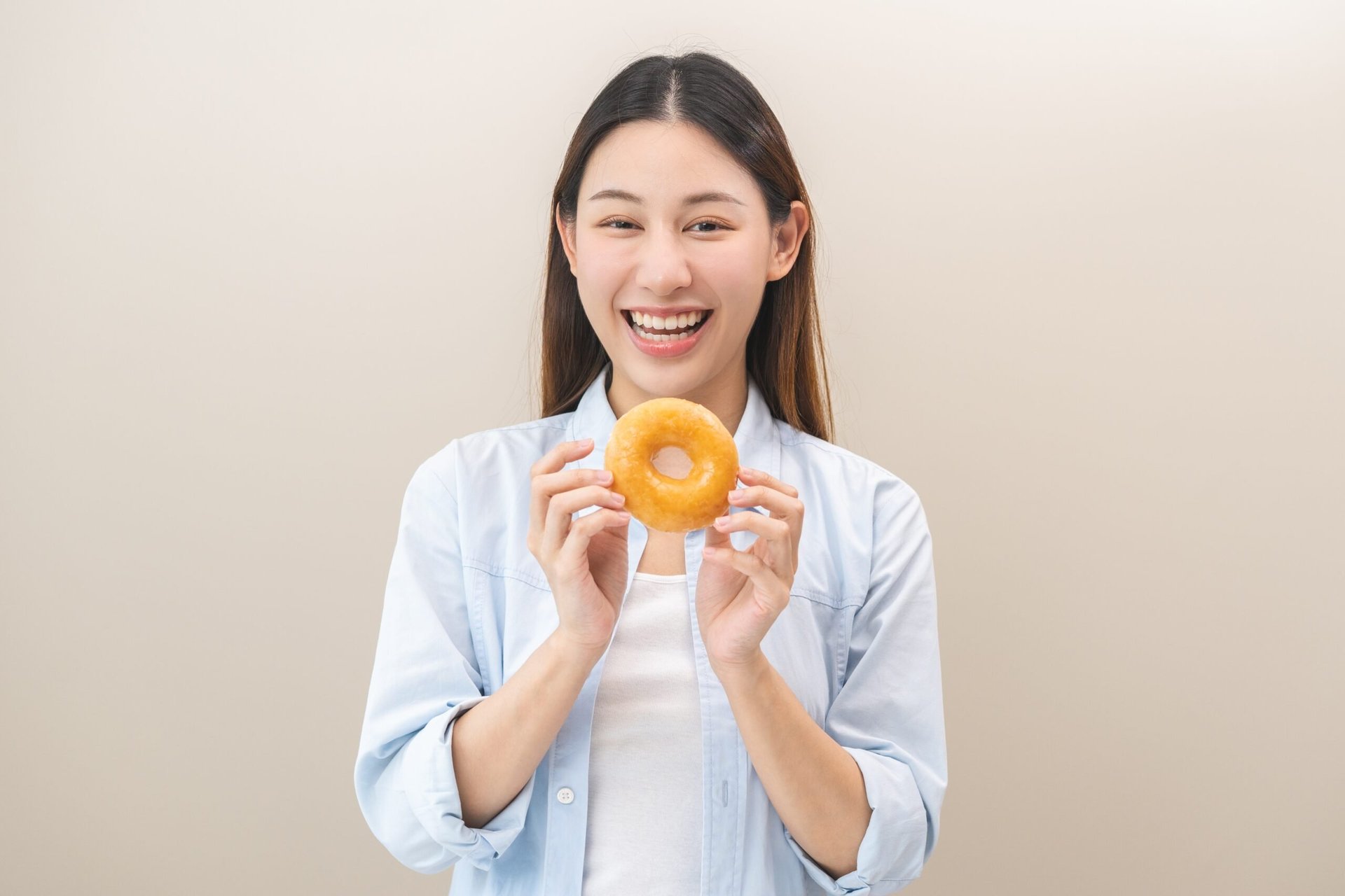 Woman holding a glazed donut