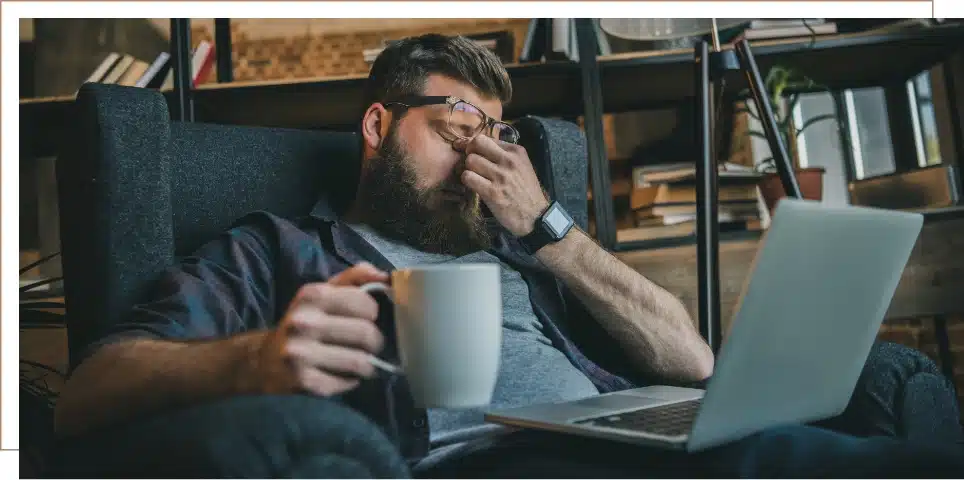 A man with his hands on his closed eyes feeling fatigue